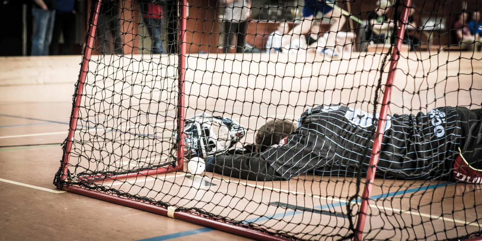 Tor mit Goalie frustriert am Boden liegend